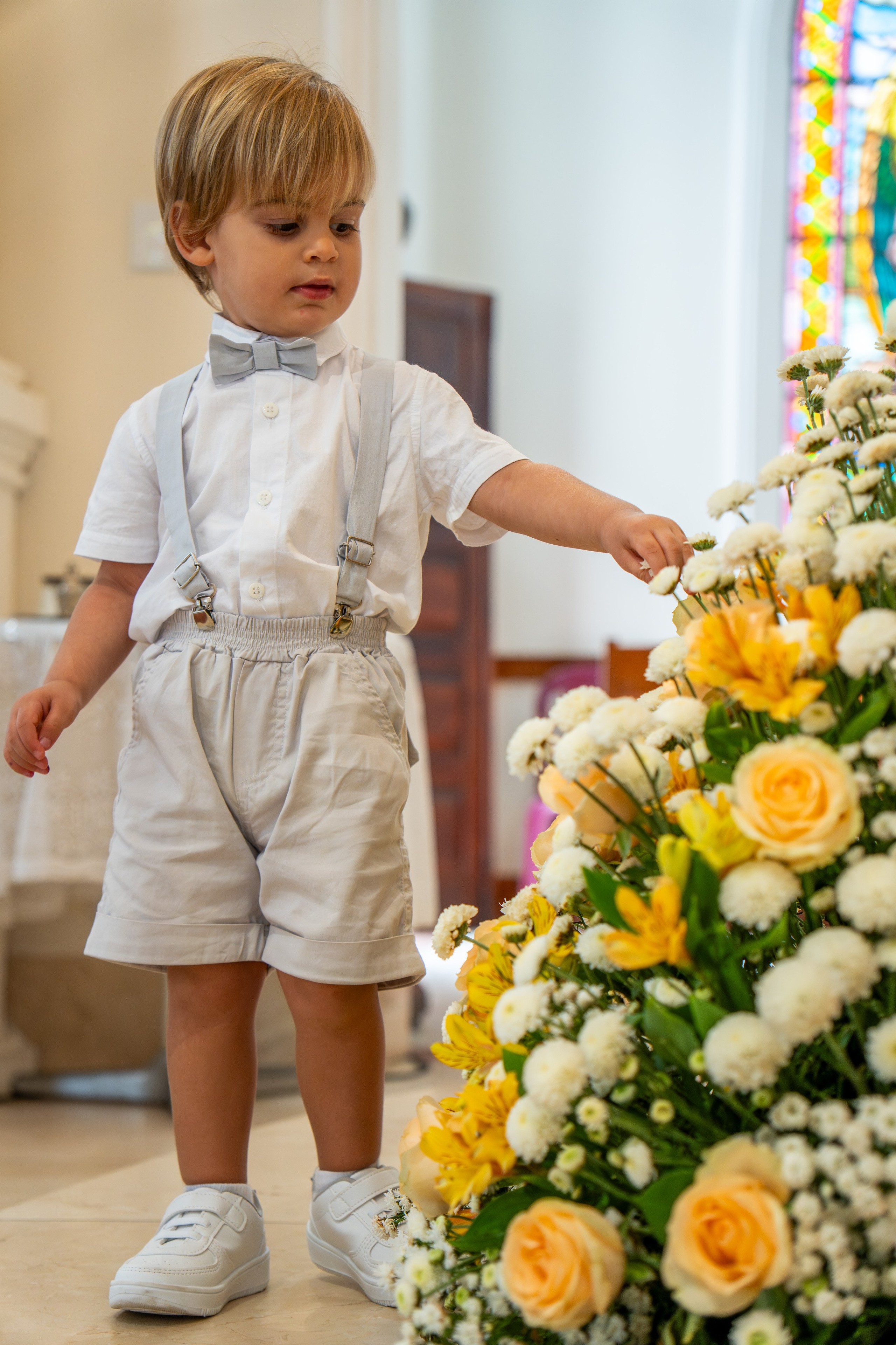 Menino vestido para Batizado durante celebração religiosa