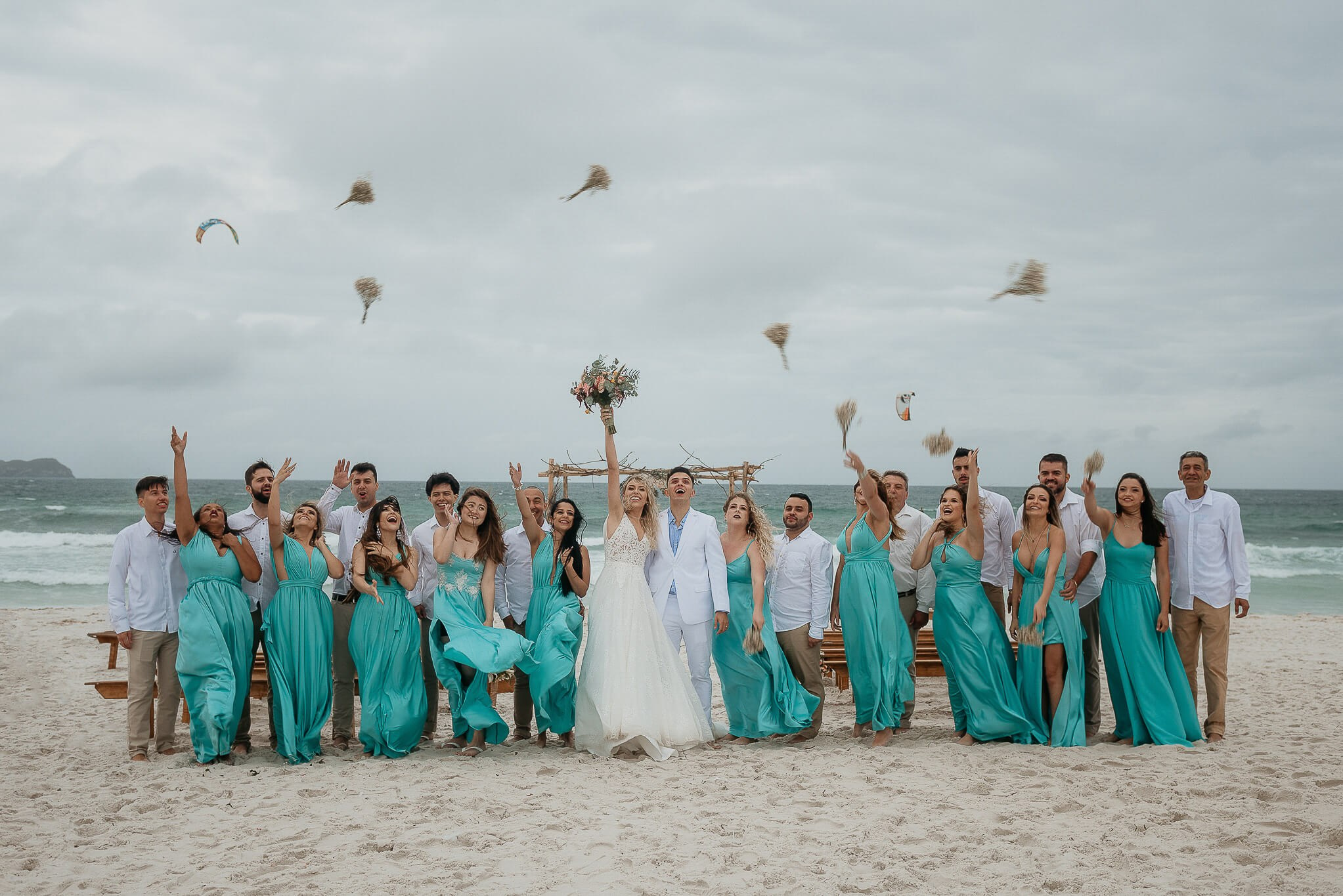 Noiva e madrinhas arremassando buquês em casamento na praia no rio de janeiro