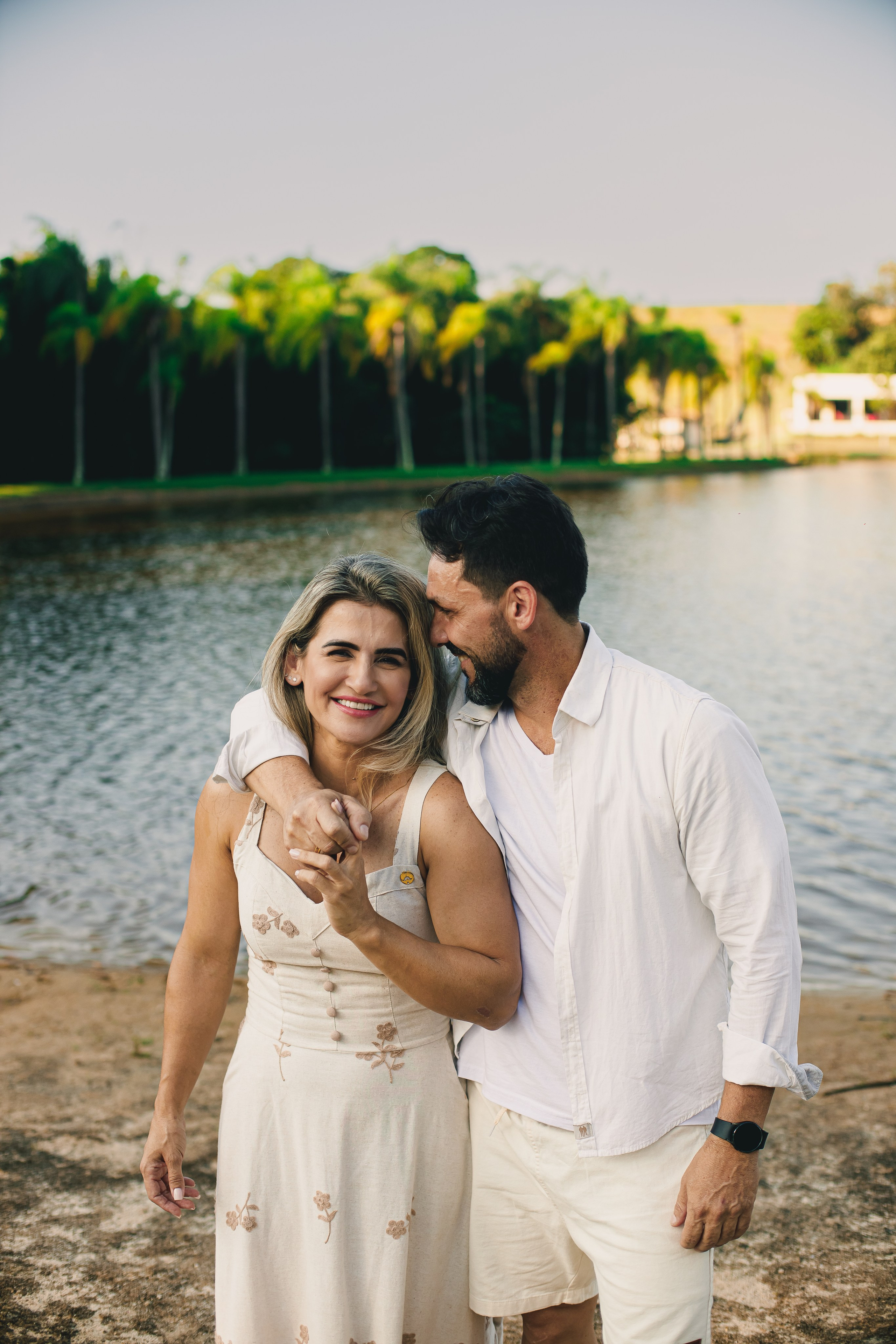 Casal apaixonados à beira do lago do Resort das Oliveiras em Porto Feliz, com luz dourada do fim de tarde