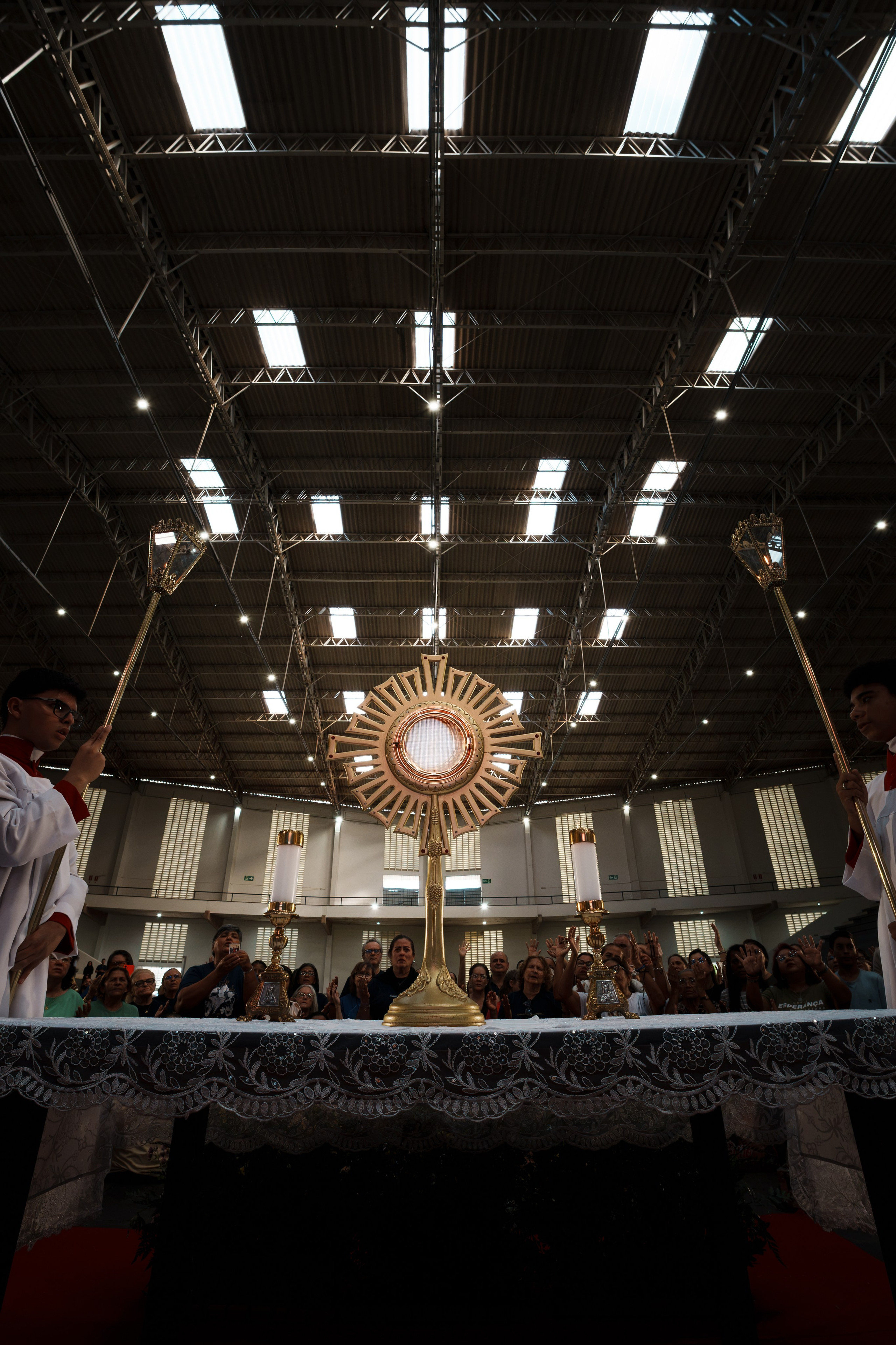 Interior de igreja com altar iluminado durante celebração religiosa do Santíssimo Sacramento