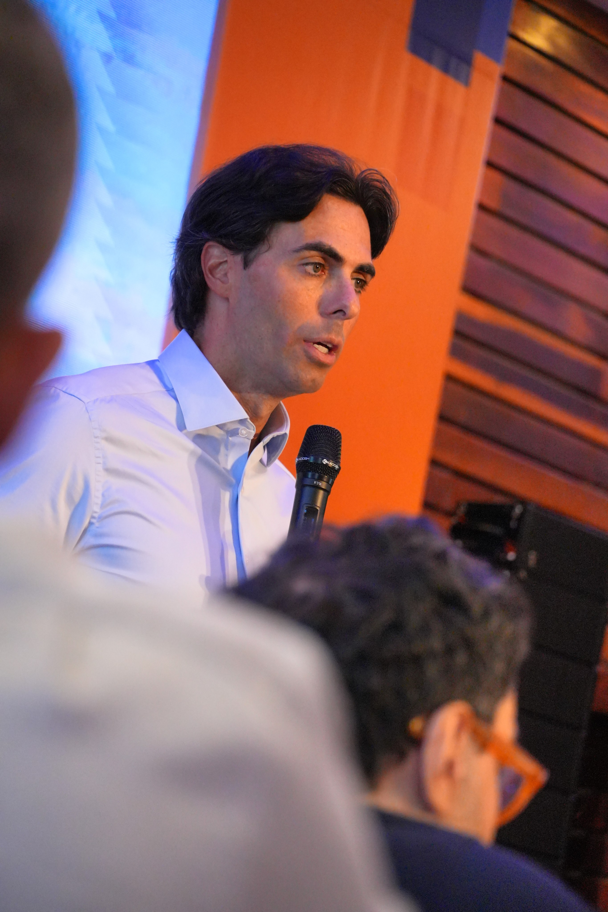 Homem falando ao microfone durante apresentação em evento de lançamento da Un1ca Natal