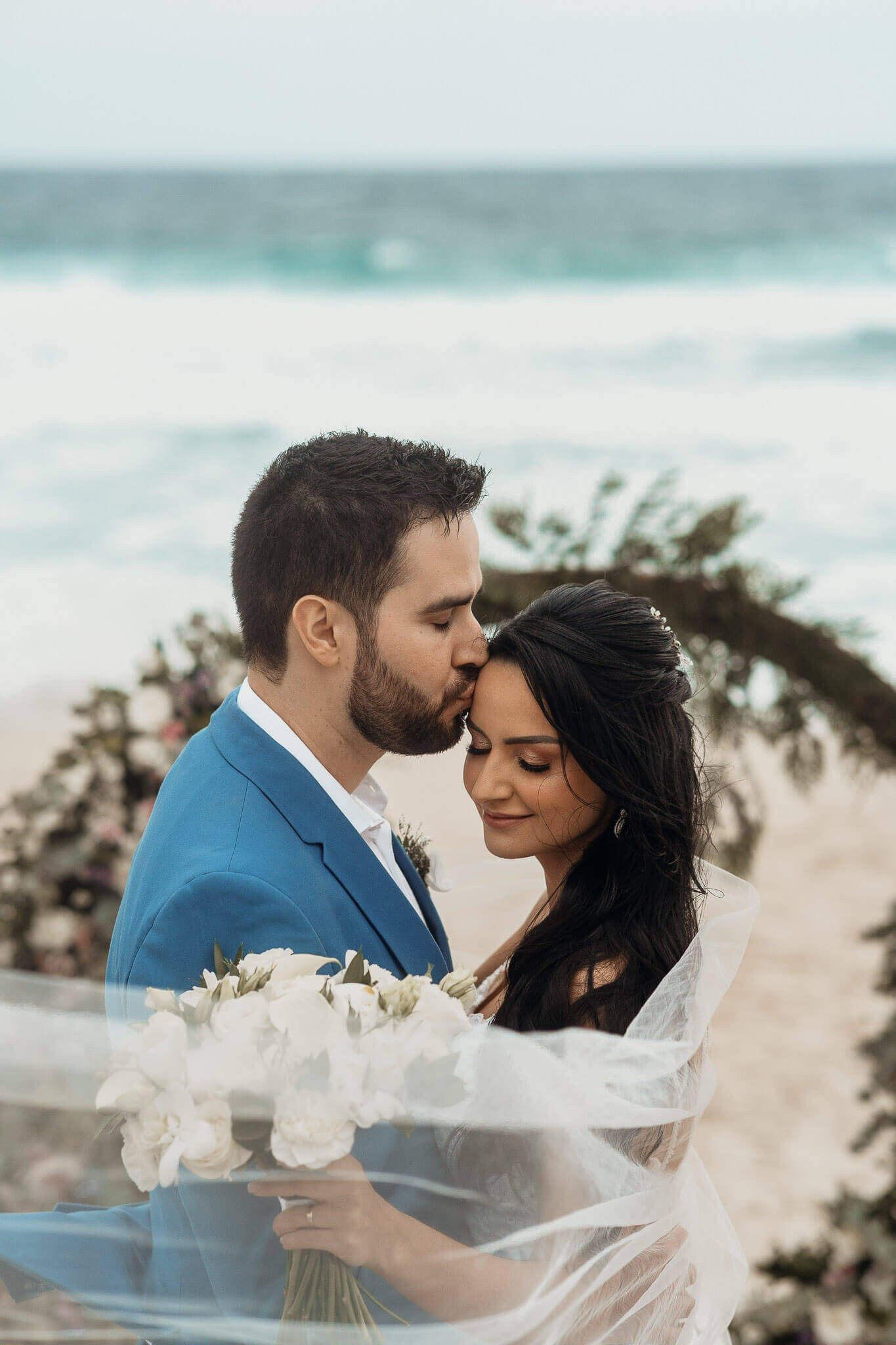 Noivo beijando a noiva em casamento na prara no Rio de Janeiro
