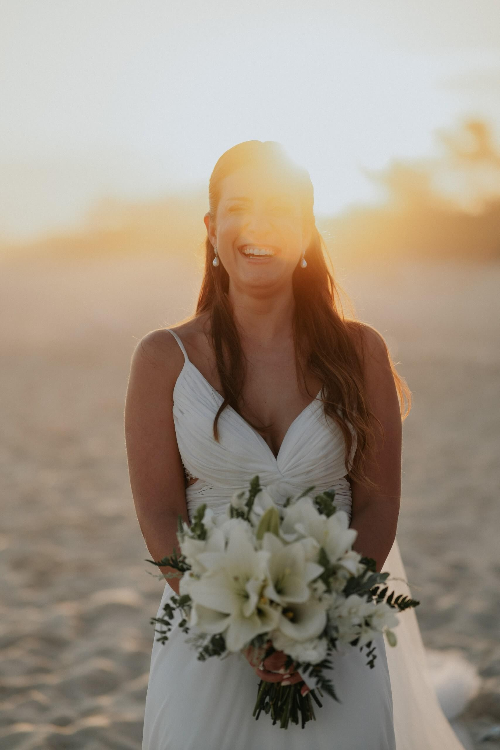 Retrato da noiva com o buquê no pôr do sol em casamento na praia no Rio de Janeiro