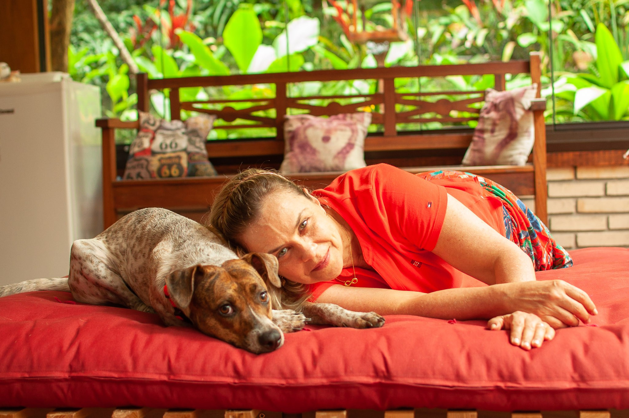 Ensaio pessoal feminino. Mulher e cachorro deitados com as cabeças um do lado do outro.
