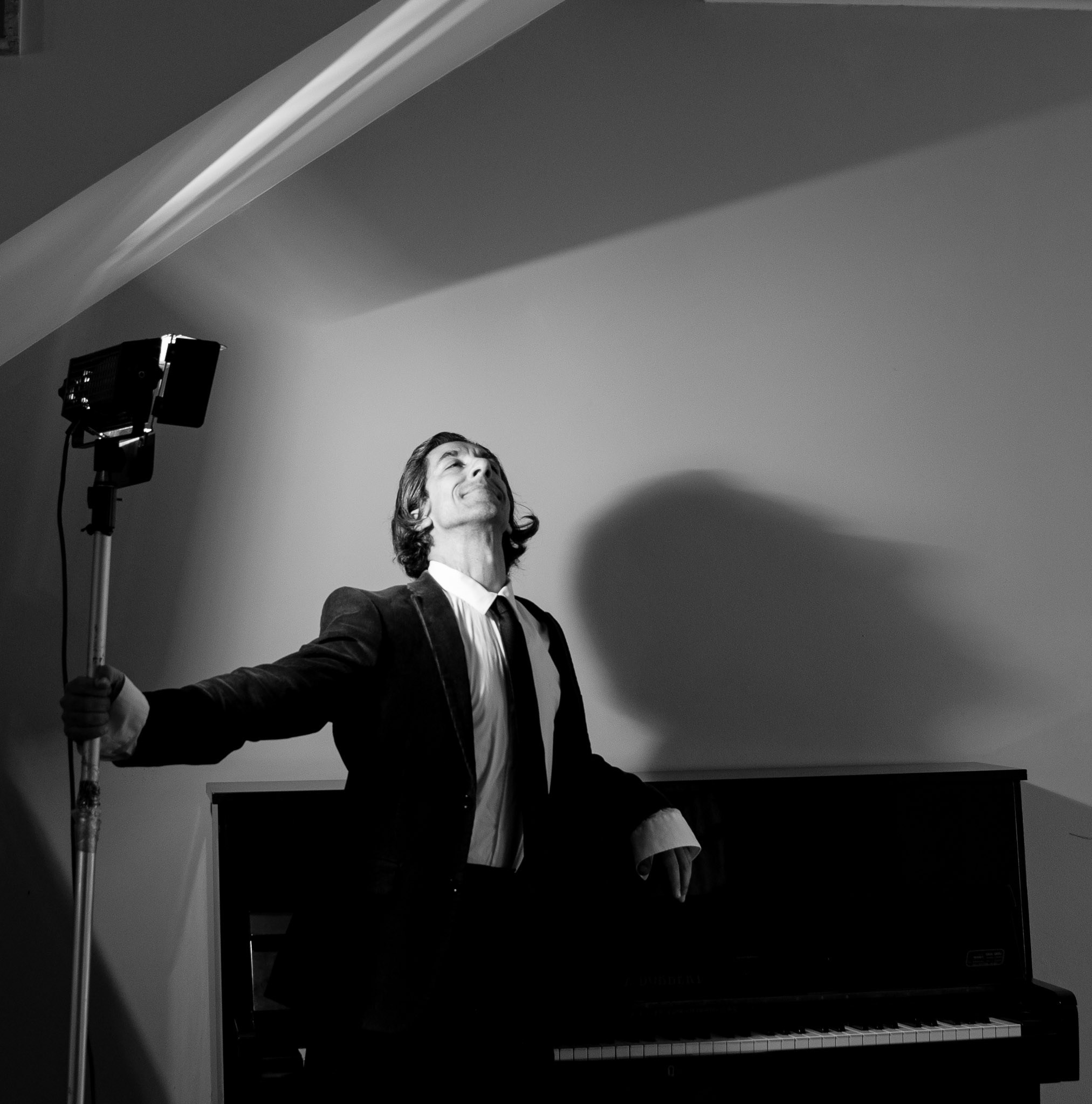 retrato artisitco. Foto pianista com luz no fundo, preto e branco.