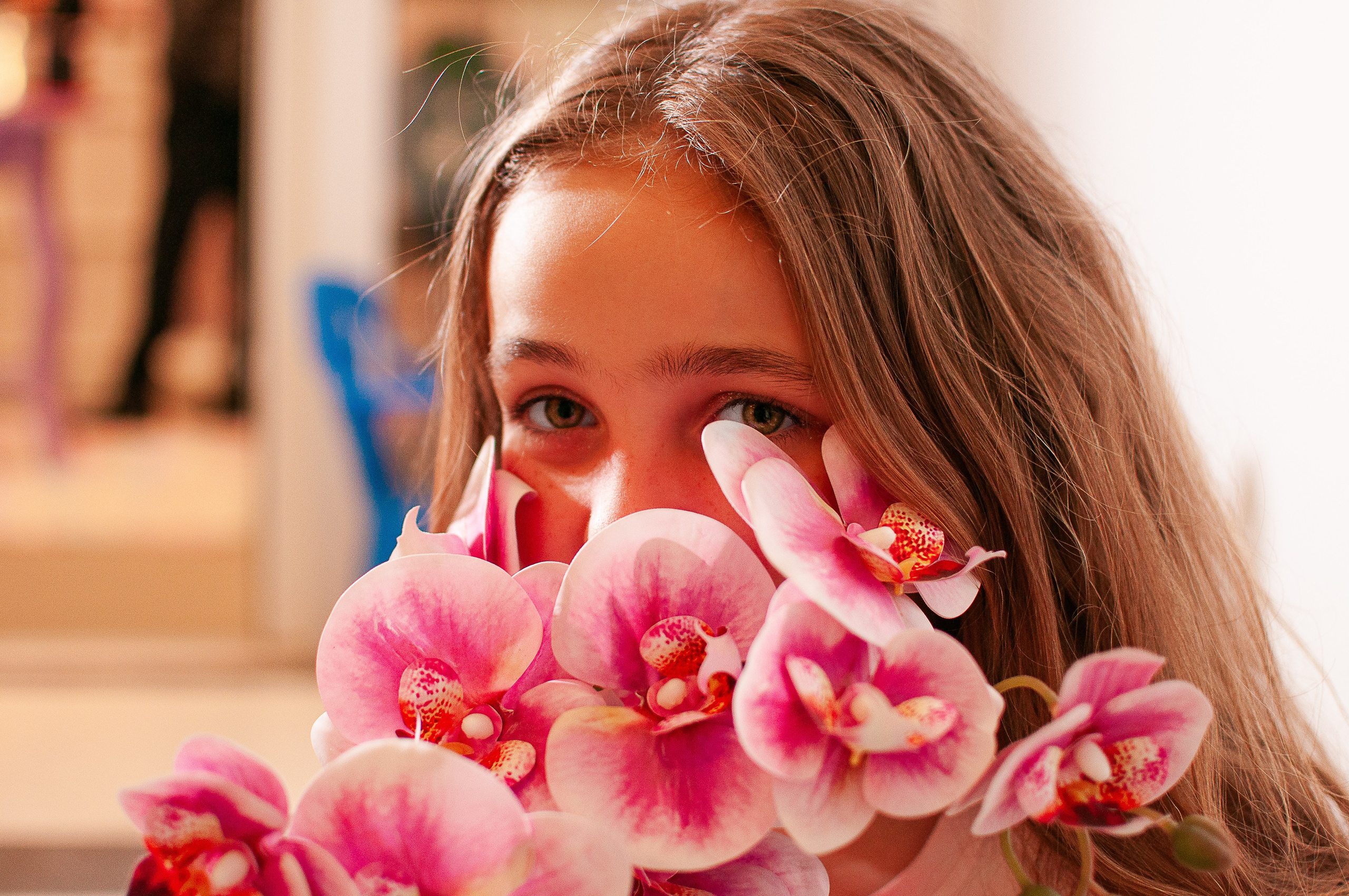 ensaio pessoal feminino. Adolescente com flores que cobrem a boa e o nariz, deixando a mostra os olhos.