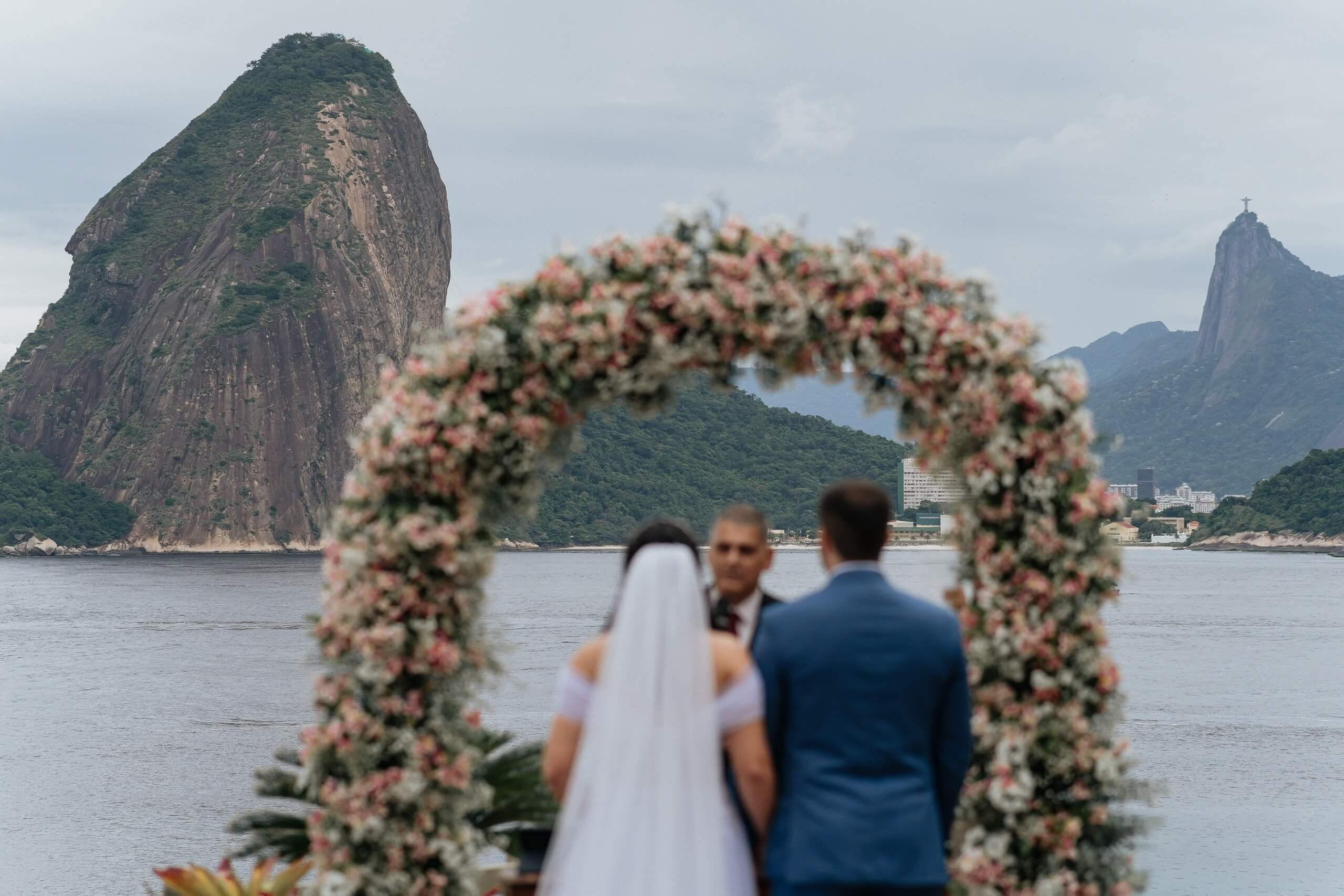 Couple wedding ceremony with Sugarloaf Mountain and Christ the Redeemer view in Rio de Janeiro, romantic destination wedding in Brazil.