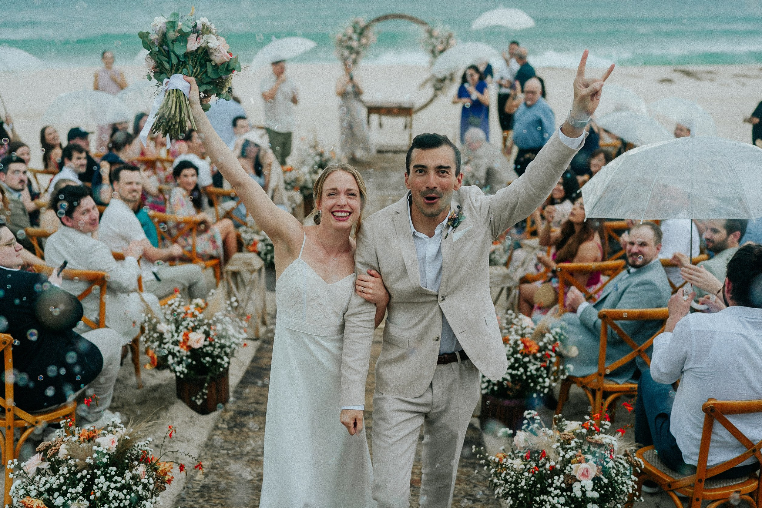 Wedding couple celebrating at Christ the Redeemer with beachside atmosphere at Som do Mar, romantic destination wedding in Rio de Janeiro.