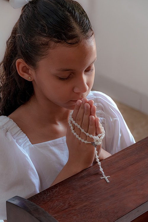 Menina em vestido branco durante celebração ddo batismo