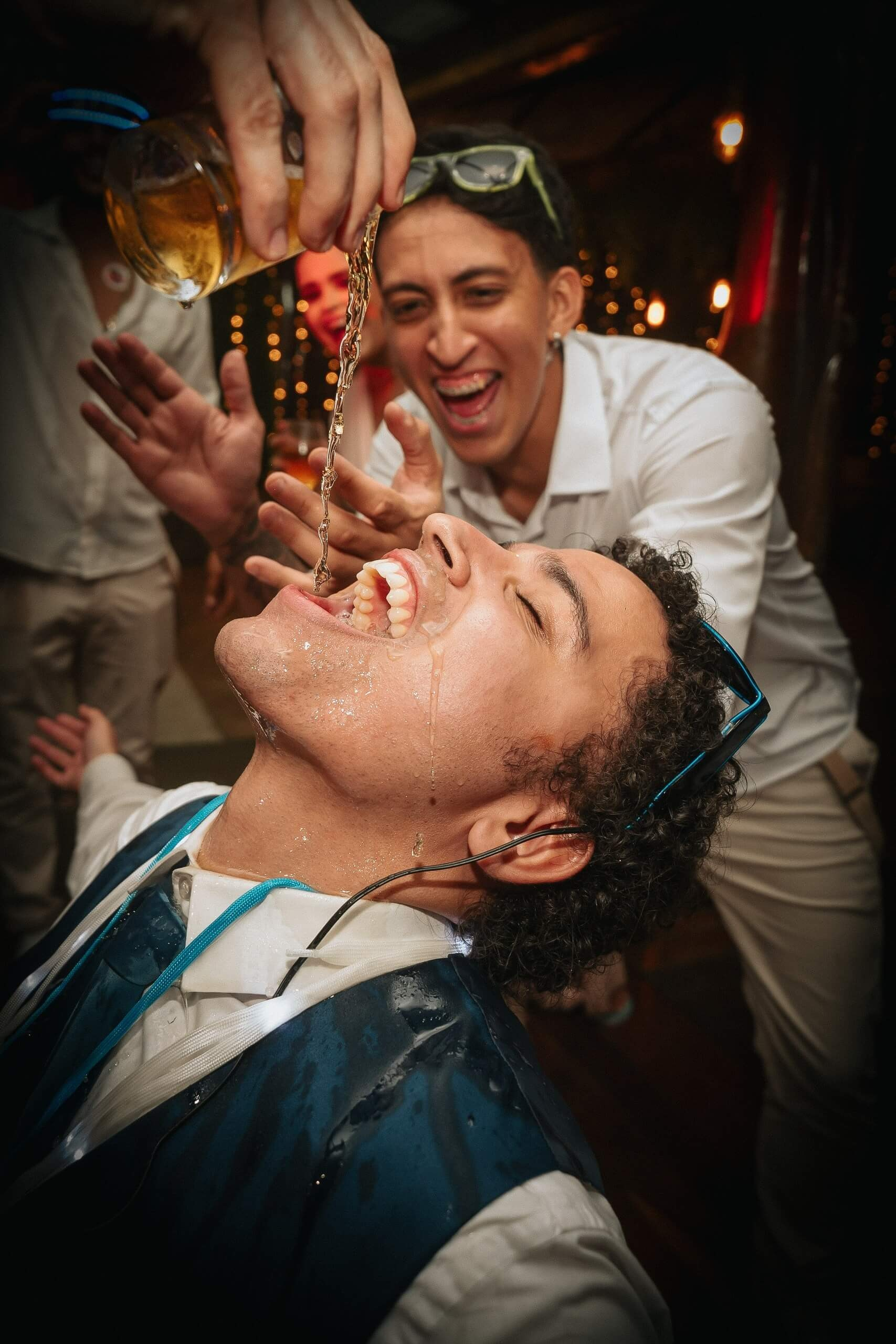 Groom having fun with drinks at wedding party in Rio de Janeiro, lively destination wedding in Brazil.