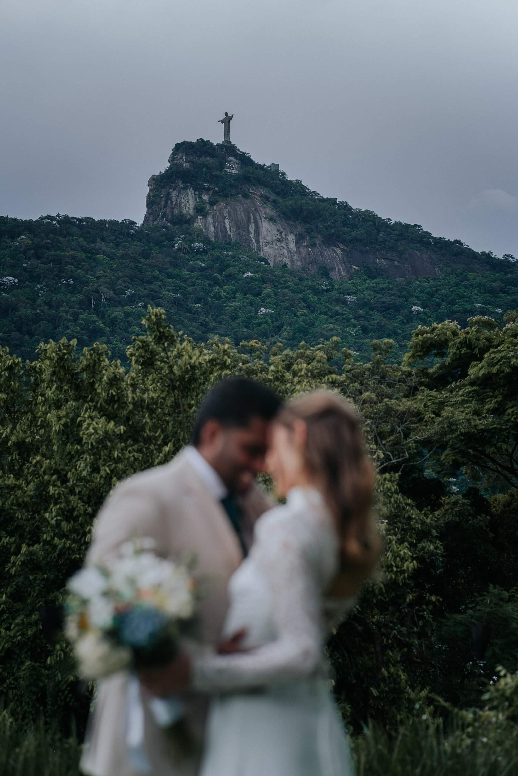Intimate elopement wedding with couple at Christ the Redeemer in Rio de Janeiro, romantic destination wedding in Brazil.